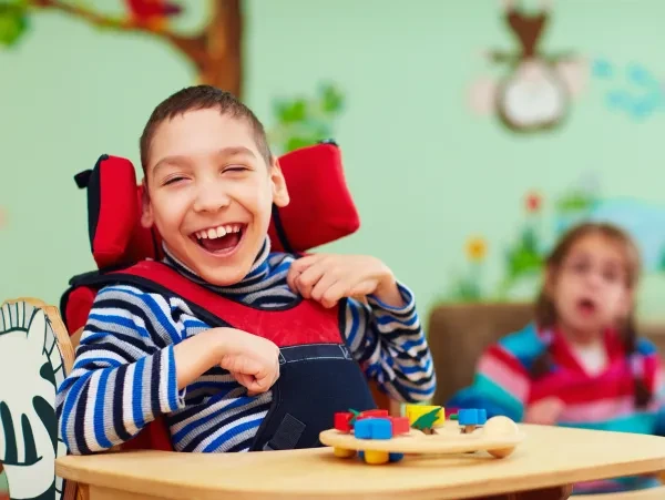 Child in adaptive therapy setting laughing